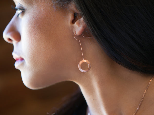 Profile view of model face and neck with a Pareure 360º Series 18k Rose Gold Vermeil Small Kinetic Earring inserted in her ear
